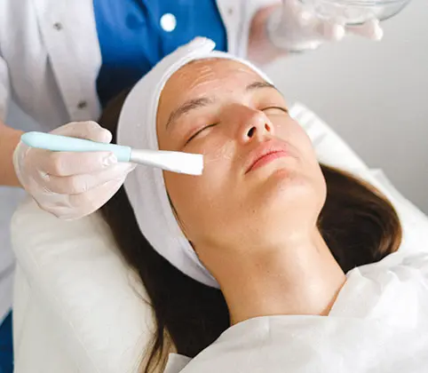 Dermatologist Brushing Chemical Peel Solution on Adult Woman's Face