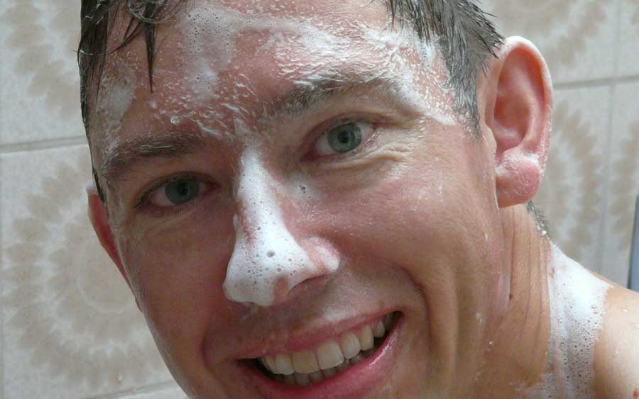 Guy in shower soaps face